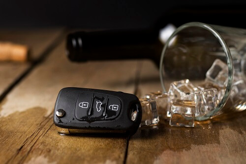 A spilled drink next to car keys, indicating a drunk driving accident.