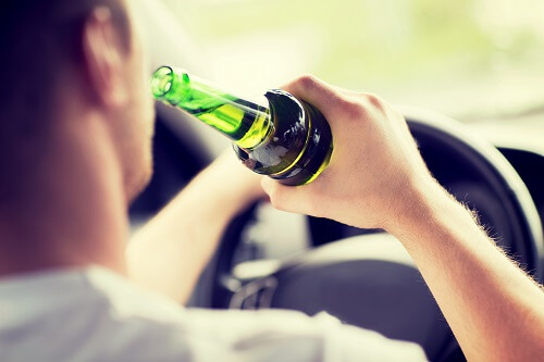 A man is drunk driving, which can lead to an accident.
