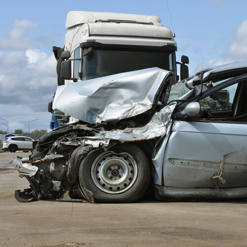 A car is crushed after a semi truck accident.