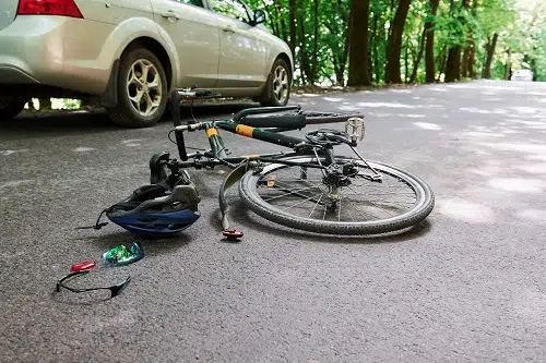A tan car is parked next to an overturned bicycle after an accident with head injuries in North Carolina.