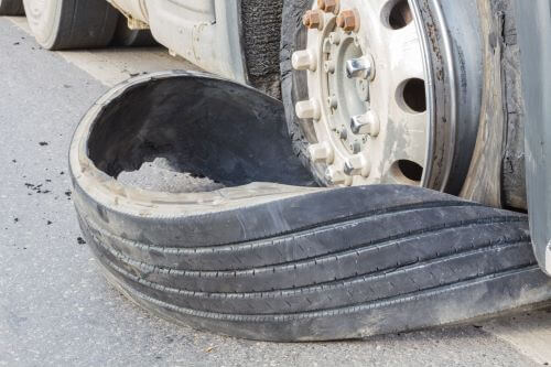 A tire is blown out on a semi after a large truck accident.