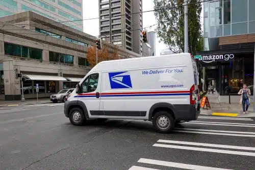 A mail truck is pictured driving through the city.
