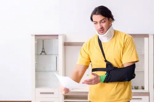 An injured man with a broken arm and neck reviews a pain and suffering settlement. 