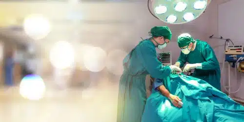 Two surgeous are performing an operation on a patient in a hospital.